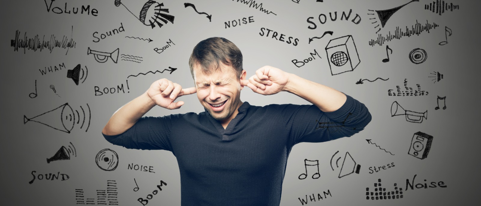 Person wearing earphones with a warning sign icon, highlighting potential hearing loss risks and safety tips from Aanvii Hearing.